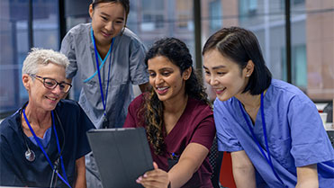 Healthcare professionals crowded around a tablet