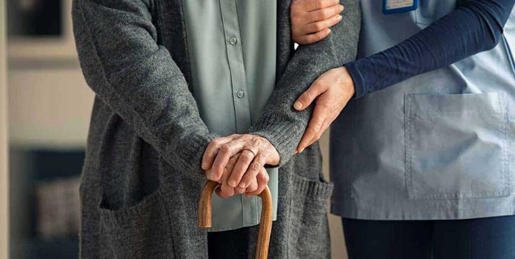 Nurse assisting elderly patient to walk