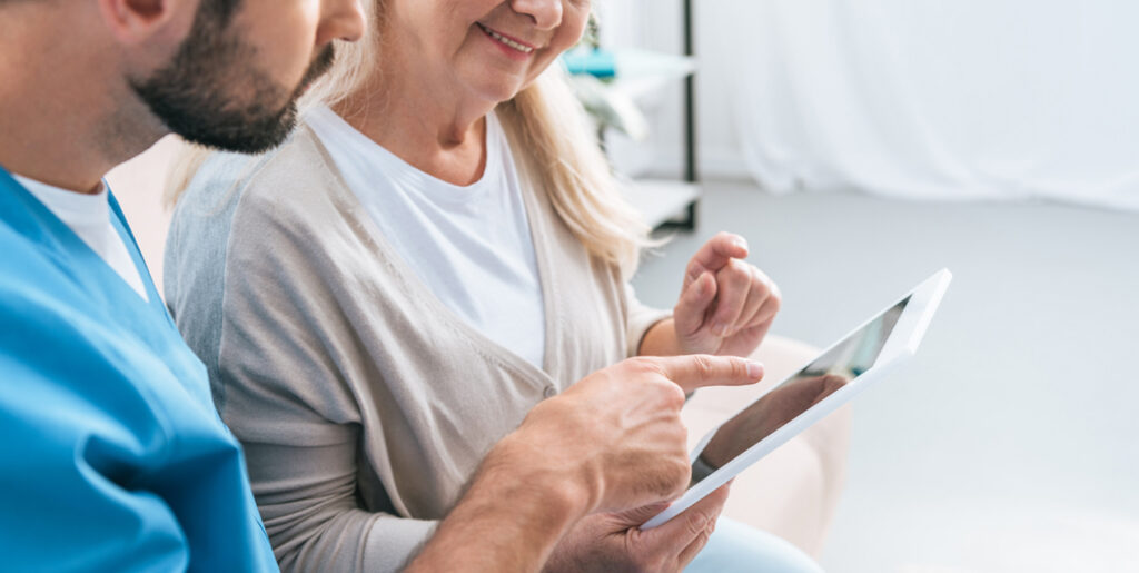 Nurse with patient showing them something on a tablet
